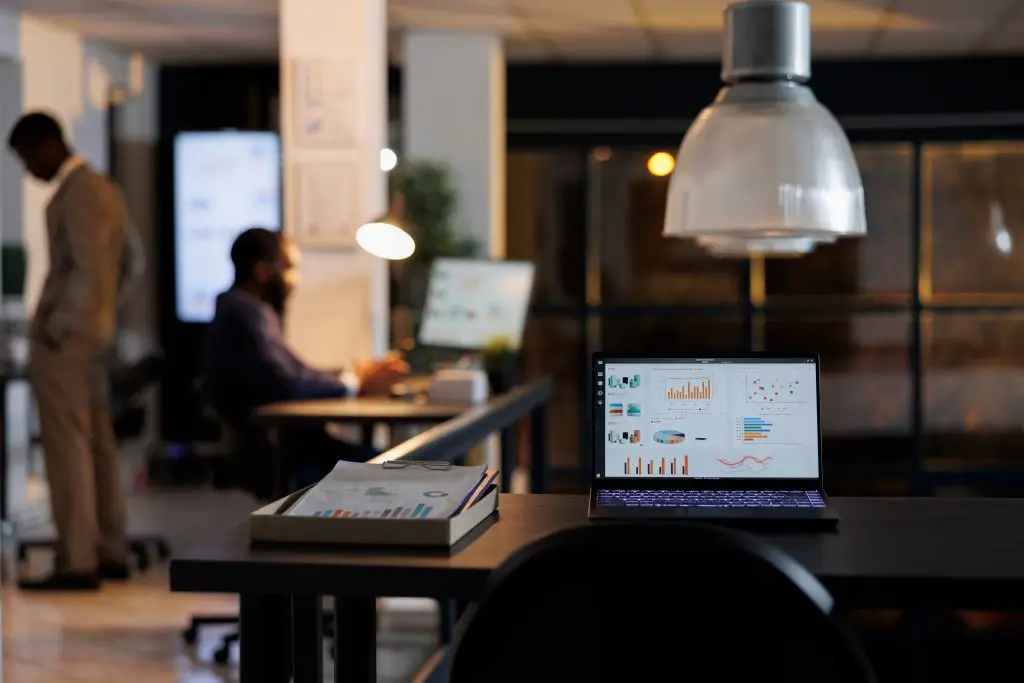 Ufficio con un laptop che mostra grafici di marketing in primo piano