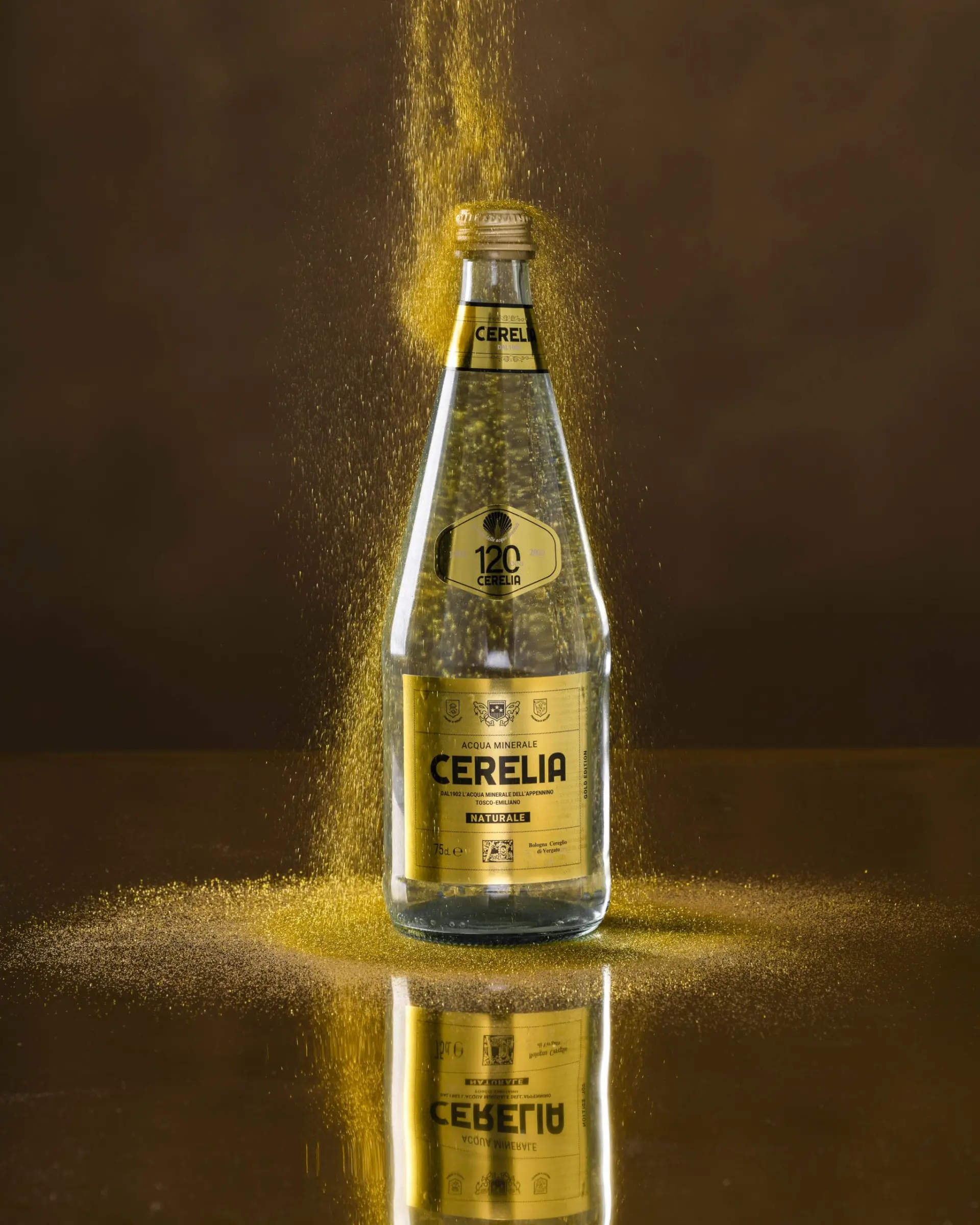 Still life della bottiglia di Acqua Cerelia su sfondo dorato